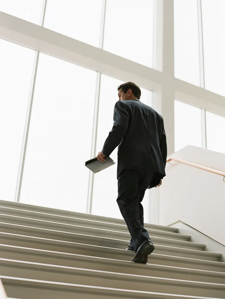 Borrower carrying an organized folder upstairs — the paperwork behind a well-built $5,000 loan request